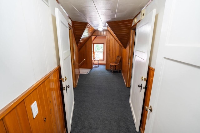 643 Park Ave, Beloit, WI 53511 - hallway featuring dark colored carpet, vaulted ceiling, and wood walls