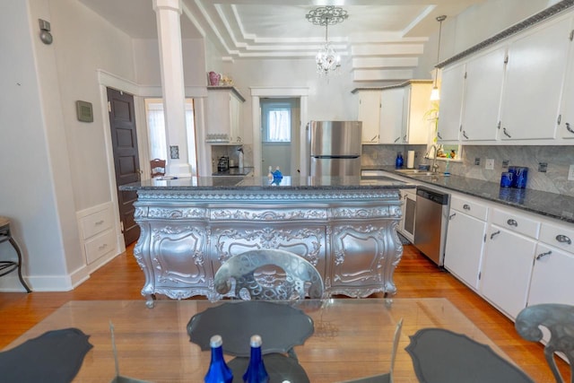 643 Park Ave, Beloit, WI 53511 - kitchen with stainless steel appliances, decorative backsplash, white cabinets, and light wood finished floors