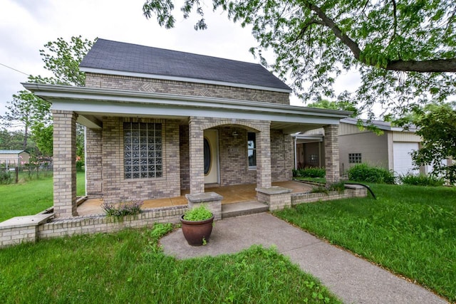 412 High St, Arena, WI 53503 - view of front of home with covered porch, brick siding, a front lawn, and roof with shingles