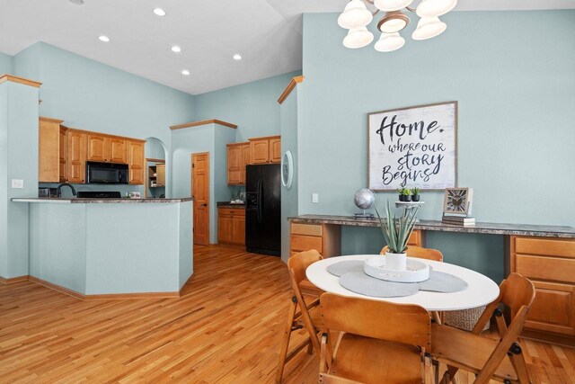 4017 Sandhill Dr, Janesville, WI 53546 - kitchen with black appliances, a chandelier, light wood-style floors, a high ceiling, and a peninsula