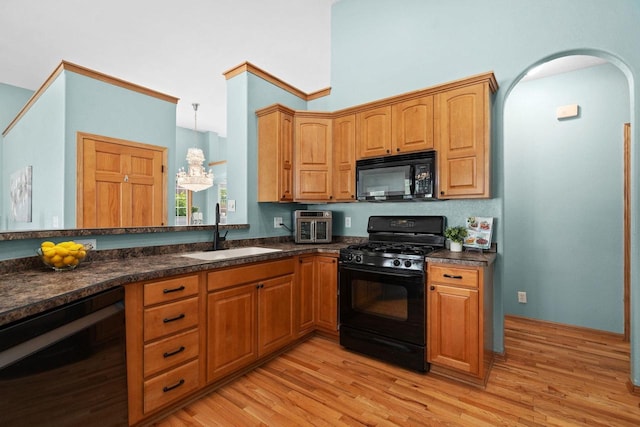 4017 Sandhill Dr, Janesville, WI 53546 - kitchen with black appliances, light wood-style flooring, a chandelier, and arched walkways