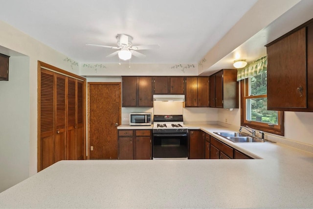 6521 Batavia Ave, Wisconsin Rapids, WI 54494 - kitchen with gas range oven, a sink, stainless steel microwave, under cabinet range hood, and light countertops