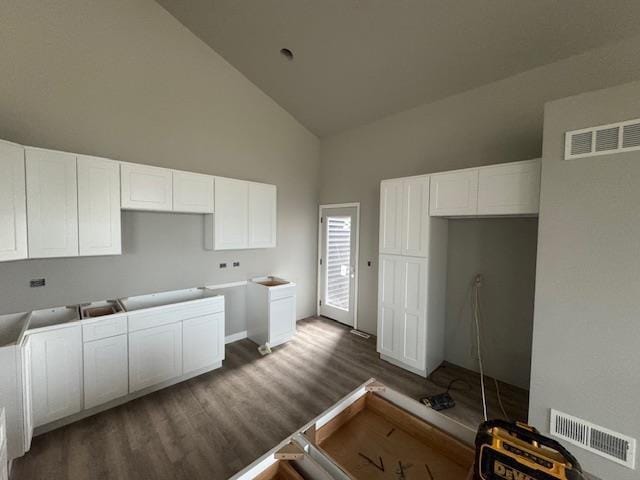 6671 Warner Farm Dr, Deforest, WI 53532 - kitchen with high vaulted ceiling, dark wood-type flooring, white cabinetry, and baseboards