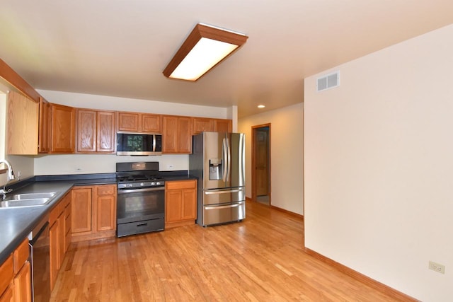 6023 241st Ave, Salem, WI 53168 - kitchen featuring appliances with stainless steel finishes, a sink, dark countertops, light wood finished floors, and recessed lighting