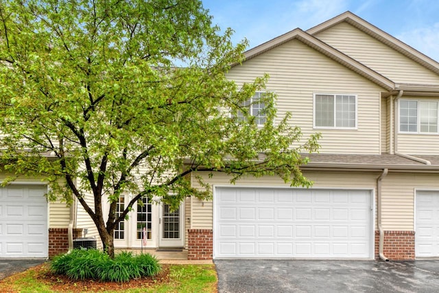 2422 Fox River Pkwy Unit B, Waukesha, WI 53189 - view of front of property featuring brick siding, asphalt driveway, cooling unit, and a garage