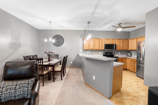 2422 Fox River Pkwy Unit B, Waukesha, WI 53189 - kitchen featuring stainless steel appliances, a peninsula, light countertops, a chandelier, and ceiling fan
