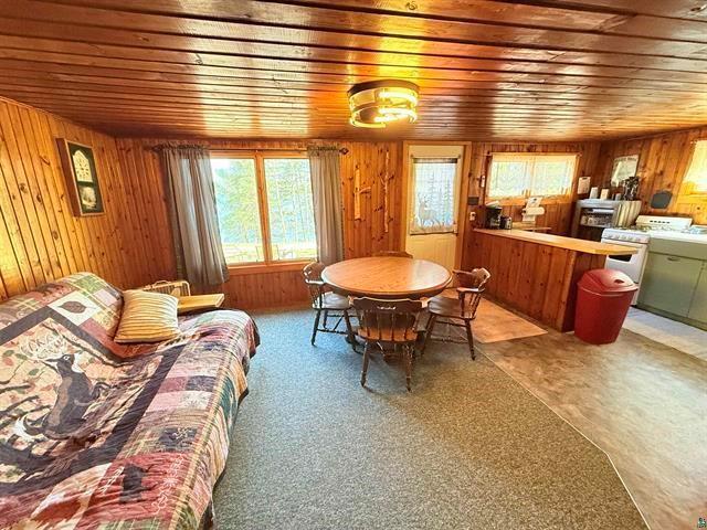 12770 Scenic Dr, Delta, WI 54847 - carpeted dining room featuring wood ceiling and wood walls