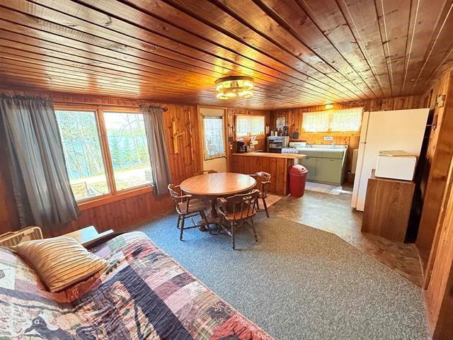 12770 Scenic Dr, Delta, WI 54847 - dining space featuring wood ceiling, wooden walls, and light colored carpet