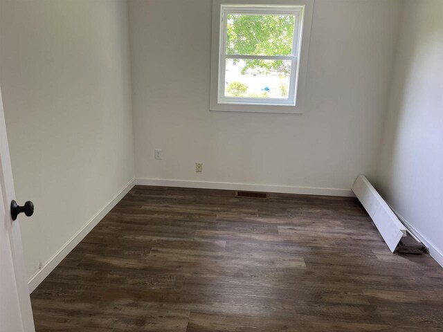 524 Charles St, Reedsburg, WI 53959 - empty room featuring baseboards and dark wood-style flooring