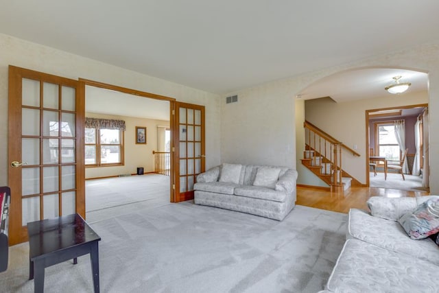 4138 Redtail Pass, Middleton, WI 53562 - carpeted living room featuring arched walkways, french doors, stairs, and baseboards