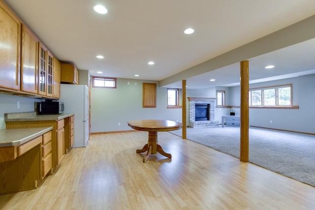 4138 Redtail Pass, Middleton, WI 53562 - kitchen featuring brown cabinetry, a brick fireplace, glass insert cabinets, light countertops, and recessed lighting