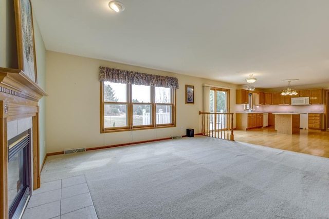 4138 Redtail Pass, Middleton, WI 53562 - unfurnished living room with light colored carpet, a chandelier, a tile fireplace, and baseboards