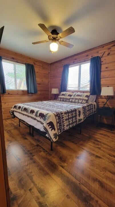 716 Skatepark Ct, Warrens, WI 54666 - bedroom featuring wood finished floors, wooden walls, and a ceiling fan