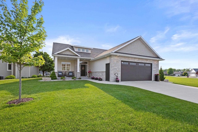 878 Whisper Falls Ln, Menasha, WI 54952 - craftsman-style home featuring stone siding, an attached garage, a front yard, concrete driveway, and covered porch