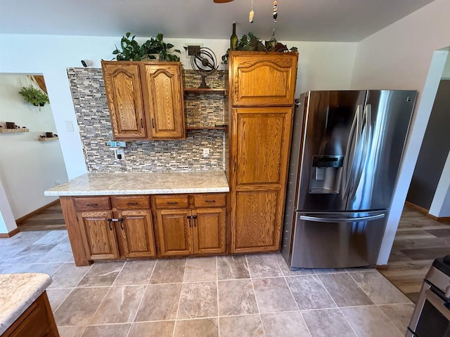 1053 Eastman Ln, Fond Du Lac, WI 54935 - kitchen featuring stainless steel fridge with ice dispenser, light countertops, brown cabinets, and tasteful backsplash