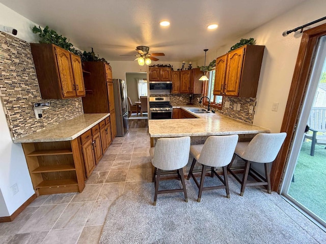 1053 Eastman Ln, Fond Du Lac, WI 54935 - kitchen featuring appliances with stainless steel finishes, a sink, open shelves, a peninsula, and decorative backsplash