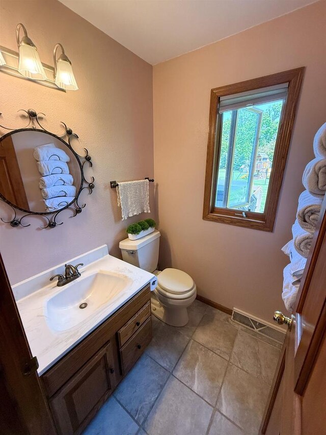 1053 Eastman Ln, Fond Du Lac, WI 54935 - half bath with vanity, toilet, tile patterned floors, and baseboards