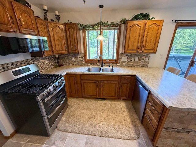 1053 Eastman Ln, Fond Du Lac, WI 54935 - kitchen featuring stainless steel appliances, a sink, brown cabinetry, and a peninsula