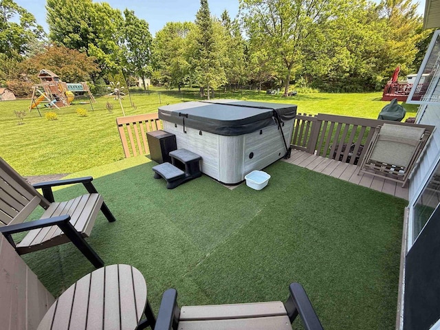 1053 Eastman Ln, Fond Du Lac, WI 54935 - view of grassy yard featuring a hot tub, a playground, view of wooded area, and a deck