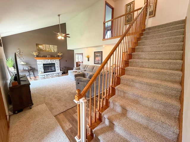 1053 Eastman Ln, Fond Du Lac, WI 54935 - stairs featuring wood finished floors, ceiling fan, a stone fireplace, and high vaulted ceiling