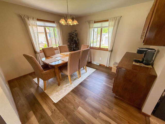 1053 Eastman Ln, Fond Du Lac, WI 54935 - dining room featuring a chandelier, dark wood finished floors, healthy amount of natural light, and baseboards