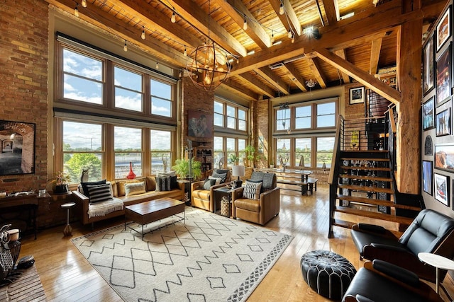 1545 Arboretum Dr Unit 315, Oshkosh, WI 54901 - living area with wooden ceiling with exposed beams, hardwood / wood-style flooring, a towering ceiling, a chandelier, and brick wall