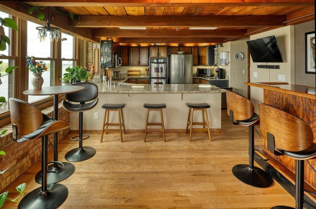 1545 Arboretum Dr Unit 315, Oshkosh, WI 54901 - kitchen featuring appliances with stainless steel finishes, wood ceiling with exposed beams, light wood finished floors, a peninsula, and dark brown cabinets