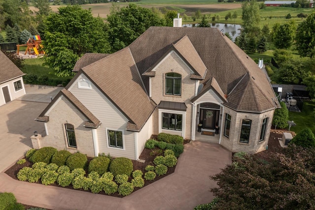 5015 Joshua Dr, West Bend, WI 53090 - french provincial home with roof with shingles, brick siding, and a playground
