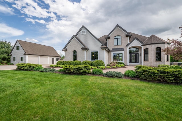 5015 Joshua Dr, West Bend, WI 53090 - french country style house featuring a front lawn and a garage