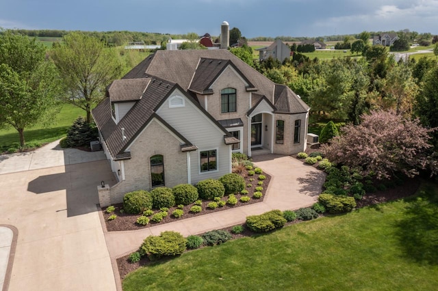 5015 Joshua Dr, West Bend, WI 53090 - french provincial home featuring roof with shingles and a front yard