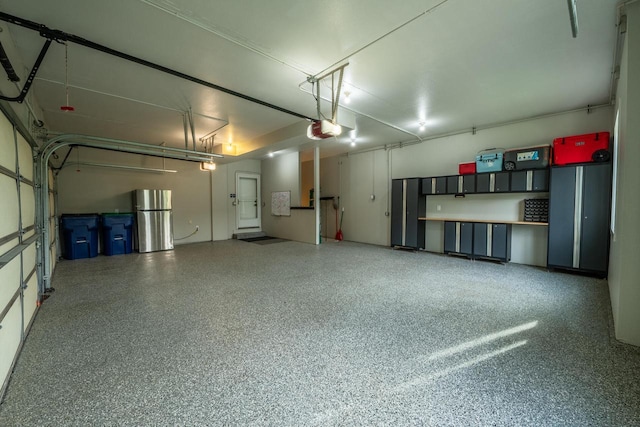 5015 Joshua Dr, West Bend, WI 53090 - garage featuring freestanding refrigerator and a garage door opener