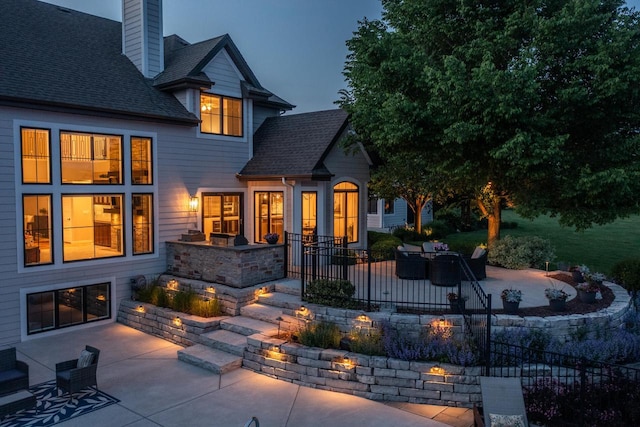 5015 Joshua Dr, West Bend, WI 53090 - back of house featuring a patio area, a chimney, and a shingled roof