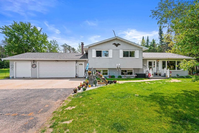 7320 Deer Rd, Wisconsin Rapids, WI 54494 - tri-level home with asphalt driveway, a front yard, and an attached garage