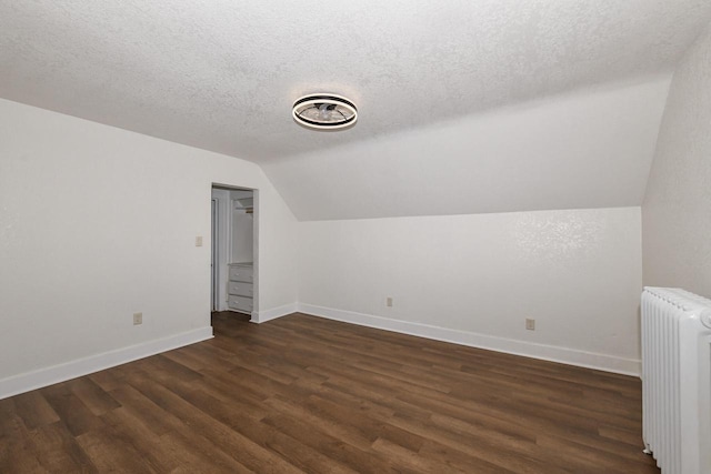 3380 N 39th St, Milwaukee, WI 53216 - additional living space featuring radiator, lofted ceiling, baseboards, dark wood finished floors, and a textured ceiling