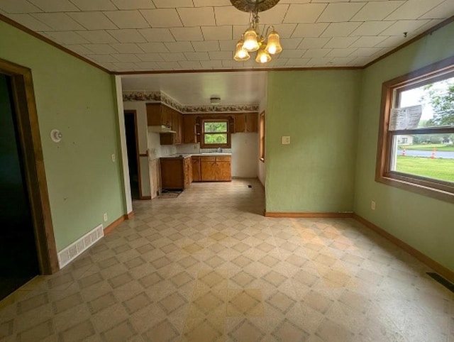 501 S Main St, Loyal, WI 54446 - unfurnished living room featuring ornamental molding, a chandelier, baseboards, and light flooring