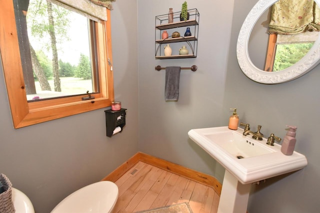 W395S3611 Hardscrabble Rd, Dousman, WI 53118 - half bathroom featuring toilet, wood finished floors, and baseboards