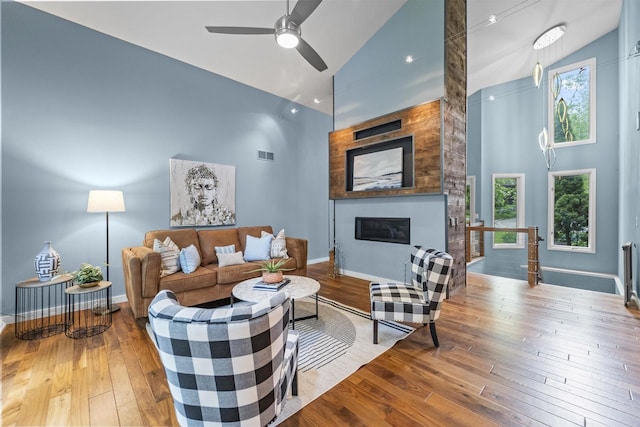 1733 Camelot Dr, Madison, WI 53705 - living area with high vaulted ceiling, hardwood / wood-style flooring, a fireplace, a ceiling fan, and baseboards