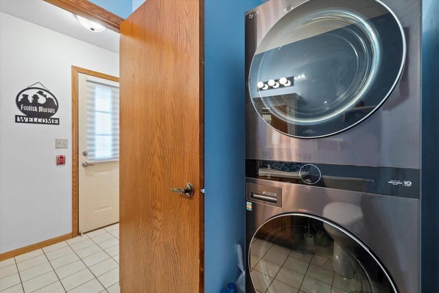 1507 Clarence Ct Unit 5, West Bend, WI 53095 - laundry area with stacked washing machine and dryer, light tile patterned floors, and baseboards