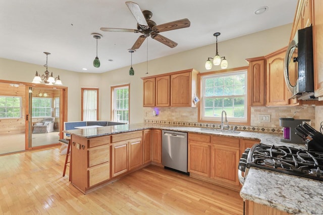 2432 Forest Hill Ct, Waukesha, WI 53188 - kitchen featuring appliances with stainless steel finishes, a sink, a chandelier, a peninsula, and healthy amount of natural light