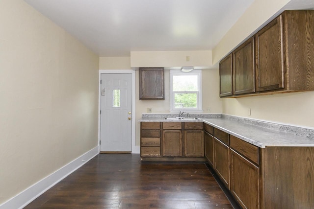 912 Harvey St, Beloit, WI 53511 - kitchen featuring dark wood-type flooring, light countertops, baseboards, and a sink