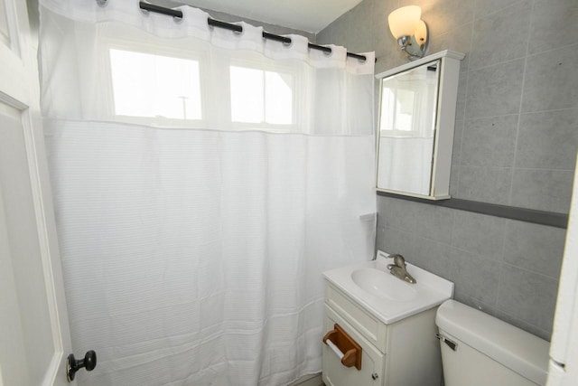 912 Harvey St, Beloit, WI 53511 - bathroom with vanity, toilet, curtained shower, and tile walls
