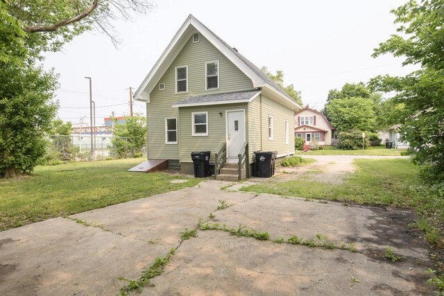 912 Harvey St, Beloit, WI 53511 - rear view of property with driveway, a yard, a shingled roof, and entry steps