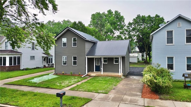 1226 Bellevue Ave, Eau Claire, WI 54703 - traditional-style house featuring metal roof, a porch, and a front lawn