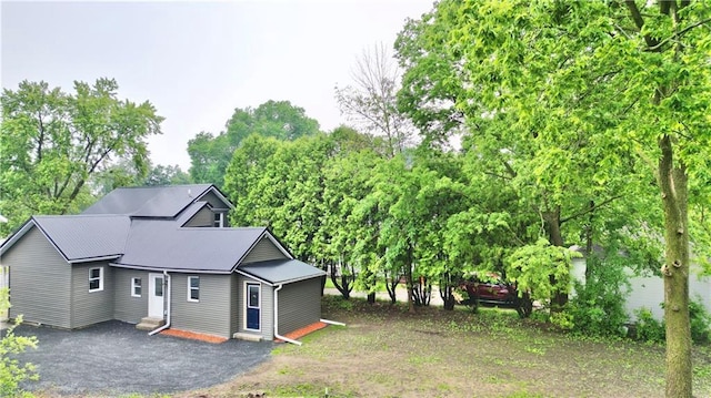 1226 Bellevue Ave, Eau Claire, WI 54703 - view of front of property featuring entry steps, view of scattered trees, metal roof, and asphalt driveway