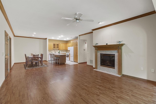 6758 Raymond Rd Unit 109, Madison, WI 53719 - living room with crown molding, wood finished floors, a ceiling fan, a tiled fireplace, and recessed lighting