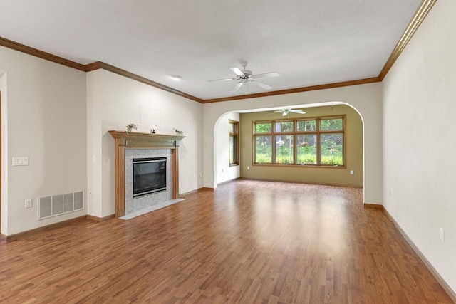 6758 Raymond Rd Unit 109, Madison, WI 53719 - unfurnished living room featuring arched walkways, a ceiling fan, wood finished floors, a tile fireplace, and crown molding