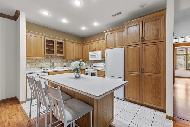 6758 Raymond Rd Unit 109, Madison, WI 53719 - kitchen with white appliances, light countertops, backsplash, glass insert cabinets, and recessed lighting