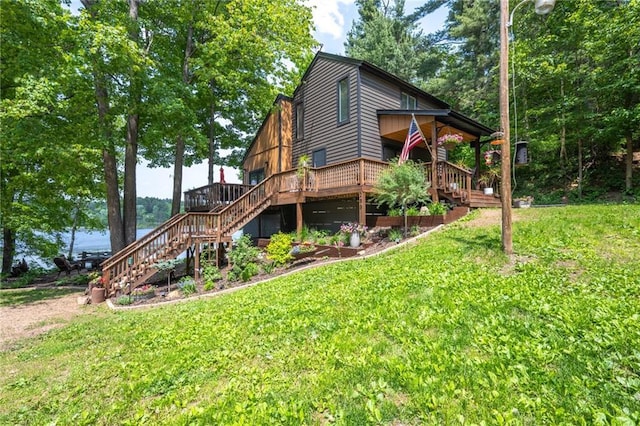 rear view of property featuring stairway, a lawn, and a wooden deck