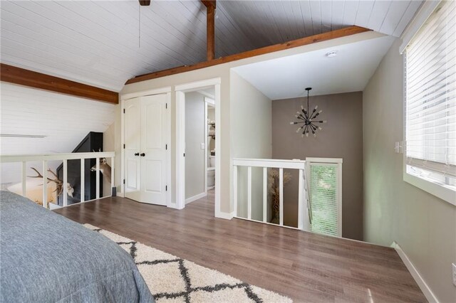 bedroom featuring a chandelier, wood finished floors, baseboards, and wood ceiling