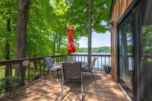 wooden deck featuring outdoor dining space and a water view